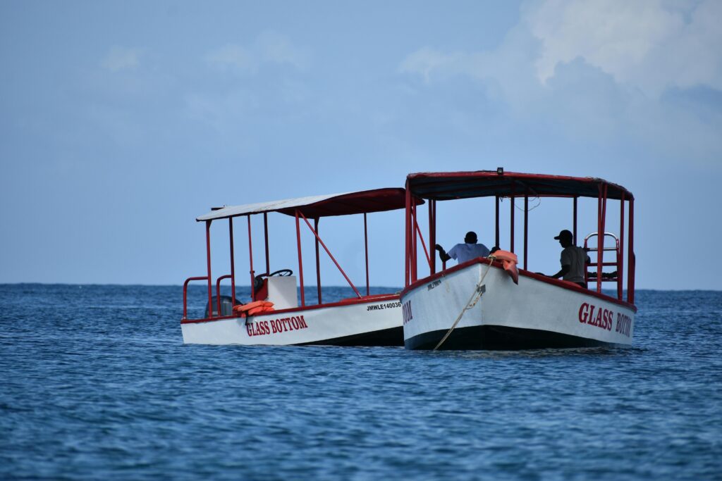 Two glass bottom boats floating on a calm ocean under a clear blue sky, perfect for leisure and exploration.
